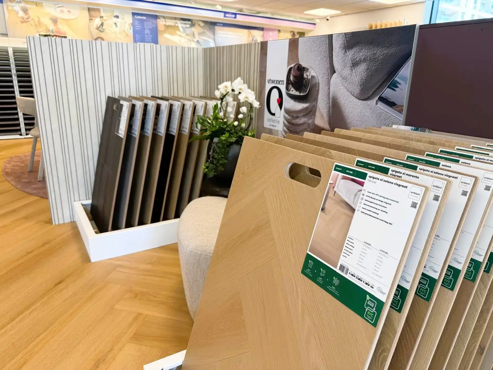 PVC-stalen in visgraat met productkaarten, naast een vtwonen-presentatie in de showroom van Leeuwenkamp